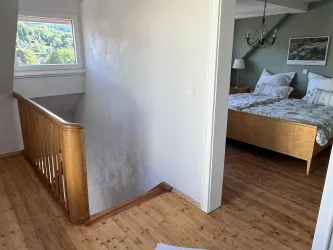Flur mit Treppe und Blick in ein Schlafzimmer