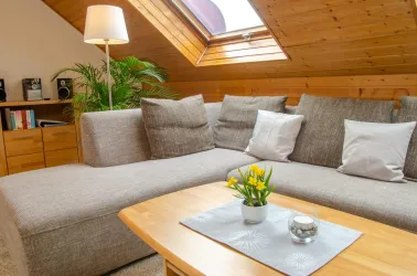 Heller Wohnbereich mit großem Sofa - Fewo im DG