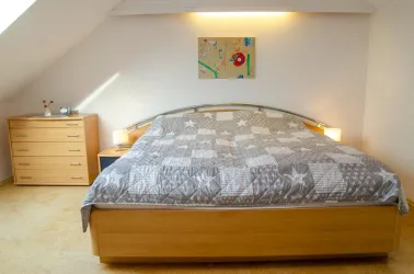 Schlafzimmer mit Schrank, Sessel + TV - Fewo im DG