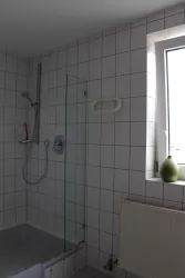 Badezimmer mit Dusche und Fenster