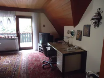 Wohnzimmer mit Schreibtisch und TV