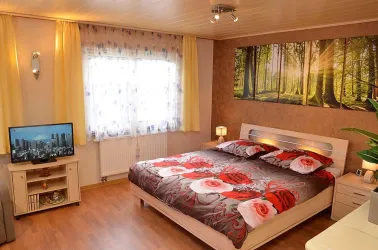 Schlaf-/Wohnbereich im OG mit Doppelbett und TV (© Gästehaus Hanß / Dominic Menzler)
