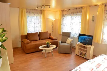 Wohnbereich im OG mit Sofa, Sessel Tisch und TV (© Gästehaus Hanß / Dominic Menzler)