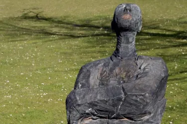 Figur mit verschränkten Armen