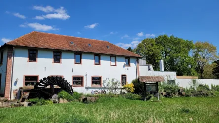 Aumühle Haßloch Hausfront mit Mühlenrad (© Tourist-Information Haßloch)