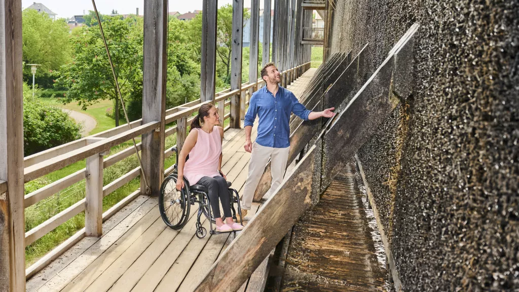 Rollstuhlfahrerin mit Begleiter auf dem Gradierwerk Bad Dürkheim