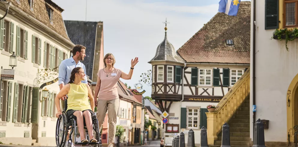 Rollstuhlfahrerin mit Begleiter und Gästeführerin in Deidesheim