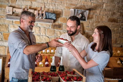 Junges Paar kauft Erdbeeren in einem Hofladen