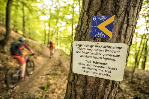 Mountainbikepark Pfälzerwald (© Andreas Meyer, Mountainbikepark Pfälzerwald e. V.) Schild mit Hinweis auf gegenseitige Rücksichtnahme im Mountainbikepark Pfälzerwald