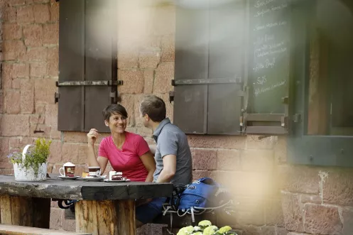 Wanderpause vor Pfälzerwald-Hütte (© Stadt Bad Dürkheim, Melanie Hubach Photographie) Zwei Wanderer genießen Kaffee und Kuchen vor einer Pfälzerwald-Hütte