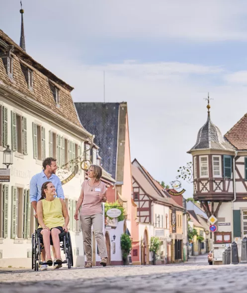 Gästeführerin mit Frau im Rollstuhl und ihrem Begleiter am Deidesheimer Marktplatz