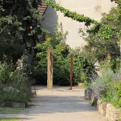 Apothekergarten mit Stein und Metallfigur (© EM Urlaubsregion Freinsheim)