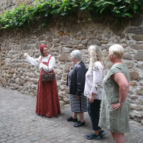 Kostumierte Stadtführerin mit drei Teilnehmerinnen