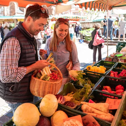 Mann und Frau an Gemüsestand auf dem Neustadter Wochenmarkt